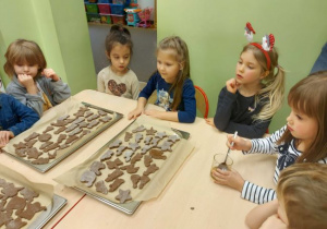 Zdjęcie przedstawia dzieci z grupy 4 z przygotowanymi blaszkami wypełnionymi pierniczkami